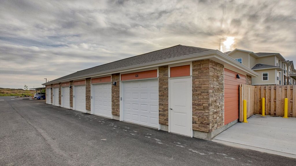 A building with a grey roof and a white garage door.