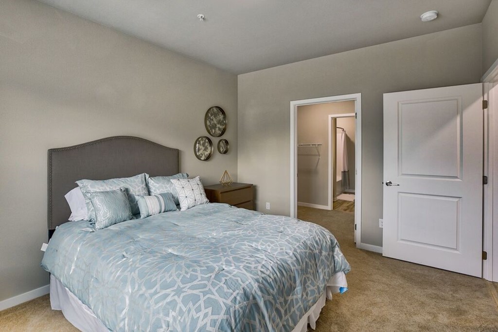 A bedroom with a large bed and a mirror on the wall.