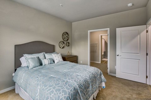 A bedroom with a large bed and a mirror on the wall.