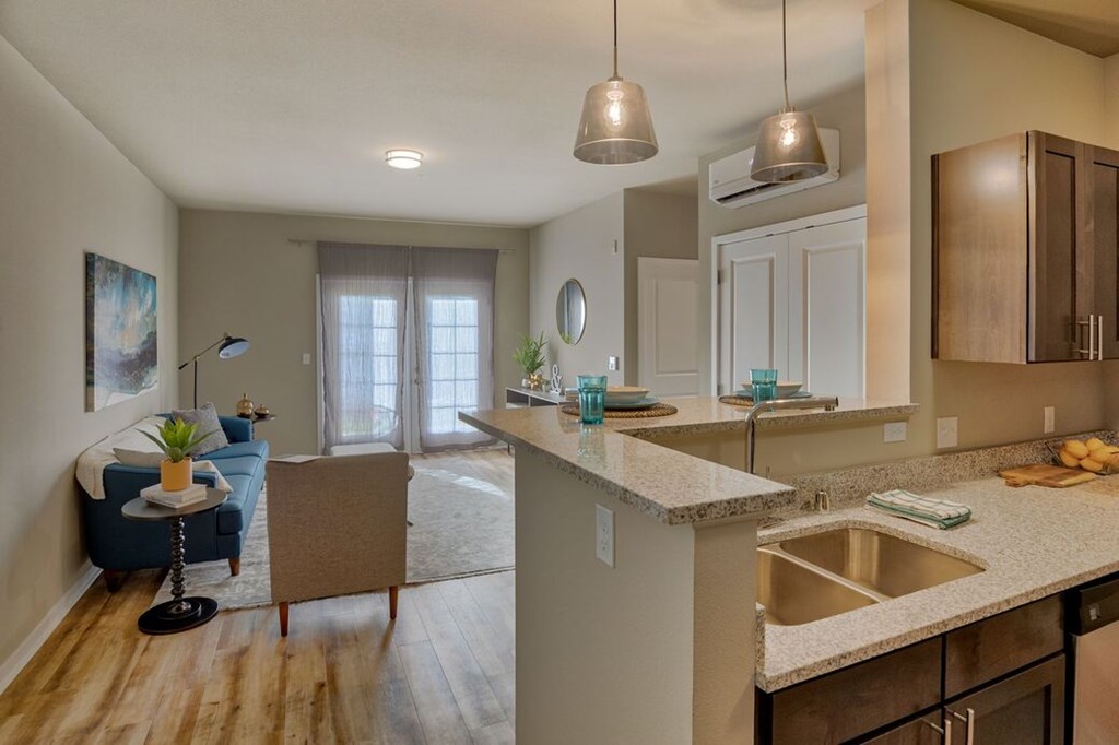 A kitchen with a sink, counter, and cabinets.