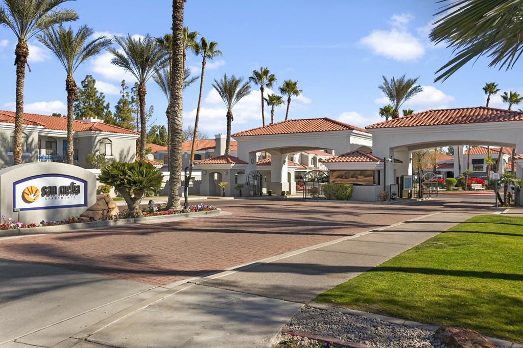 a building with palm trees and a sidewalk in front of it