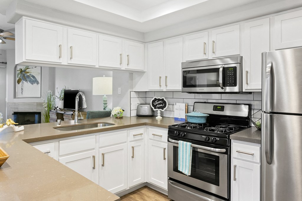 a kitchen with stainless steel appliances and white cabinets