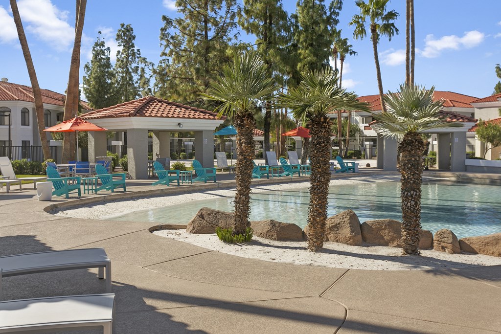 a swimming pool with palm trees and chairs around it