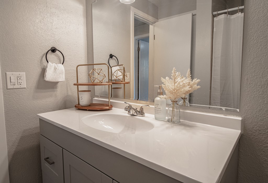 the guest bathroom has a large mirror and a white sink