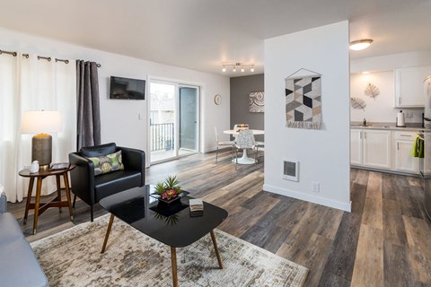 A black coffee table sits in the middle of a living room with a white couch and a television.