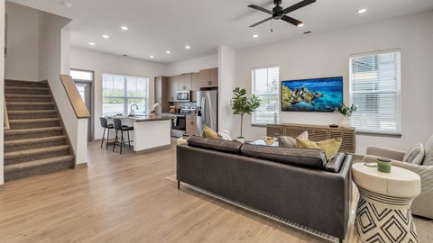 A modern living room with a grey sofa and a wooden floor.