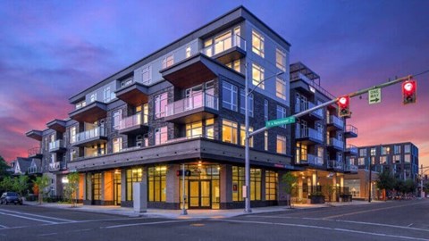 A modern multi-story building with a balcony on the second floor.