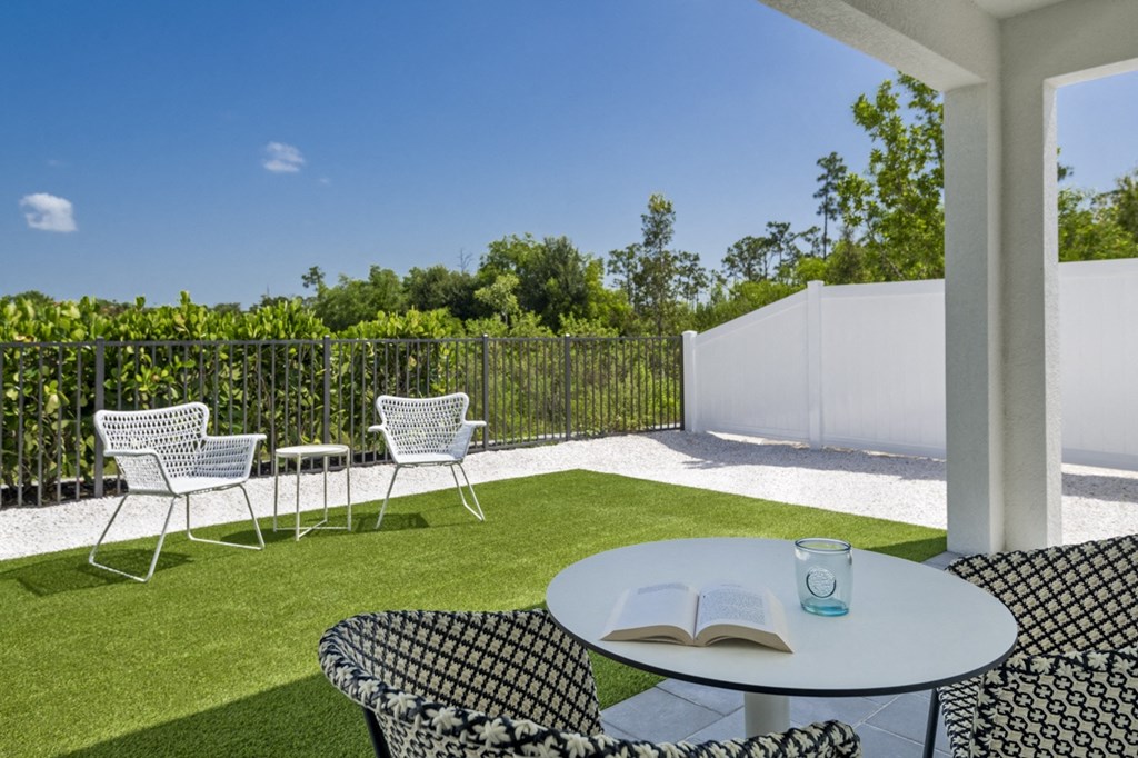 a patio with chairs and a table with a book on it