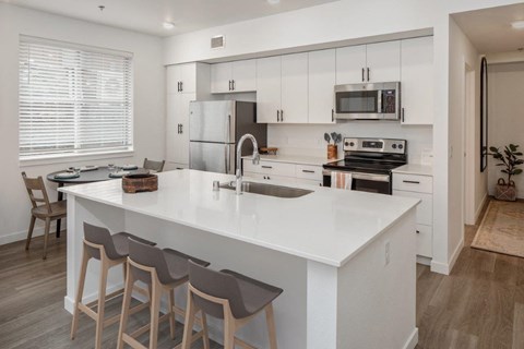 a large white kitchen with a white counter top
