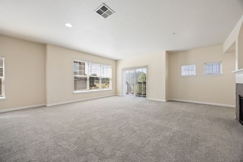 Spacious living room with large windows and sliding glass door to patio or balcony at Springwater Crossing apartments in Gresham, Oregon 97030