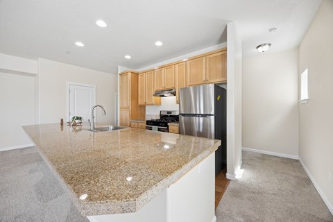 A kitchen with granite countertops and wooden cabinets.