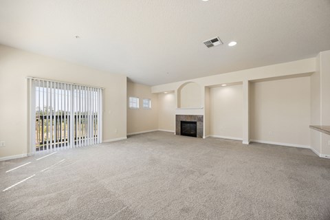 A spacious living room with a fireplace and sliding glass doors.