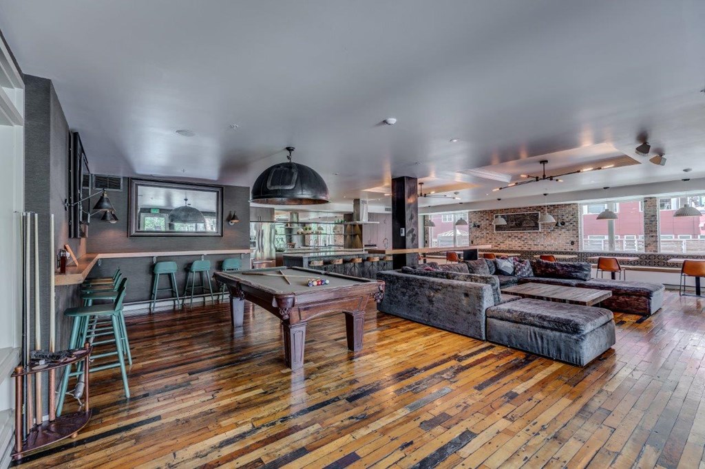 a game room with a pool table and couches
