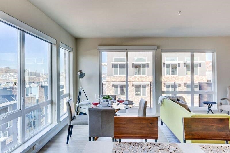 a living room with a large window and a table and chairs