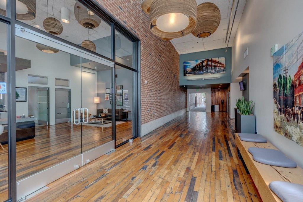 the lobby or reception area of a building with a wood floor and glass doors