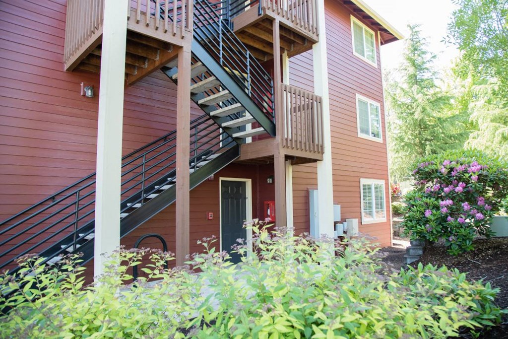 the front of a house with stairs and flowers