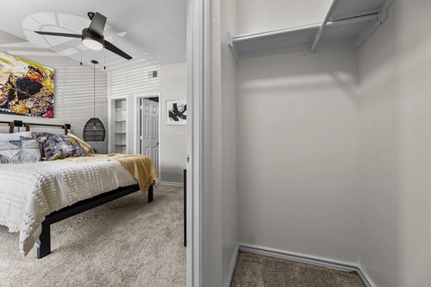 A bedroom with a bed and a ceiling fan.