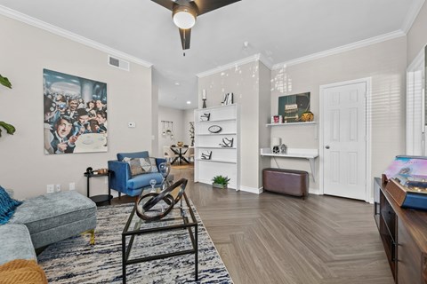 A living room with a blue couch and a painting on the wall.