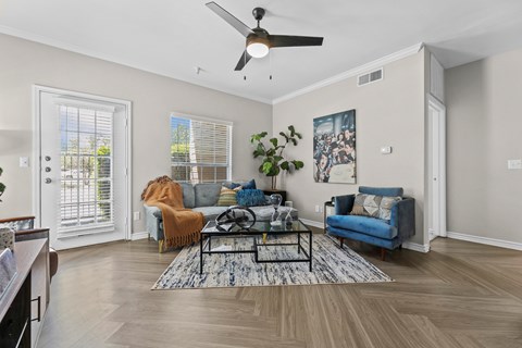 A living room with a blue couch and a rug.