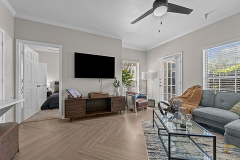 A living room with a flat screen TV mounted on the wall.