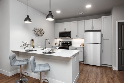 A modern kitchen with white cabinets and a white island.