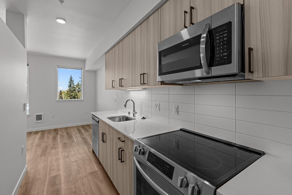 the kitchen in a new home with a stove and microwave