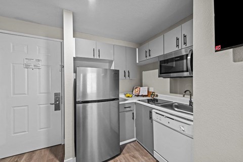 a kitchen with stainless steel appliances and white cabinets