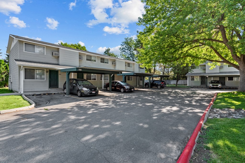 a white apartment building with cars parked in front of it