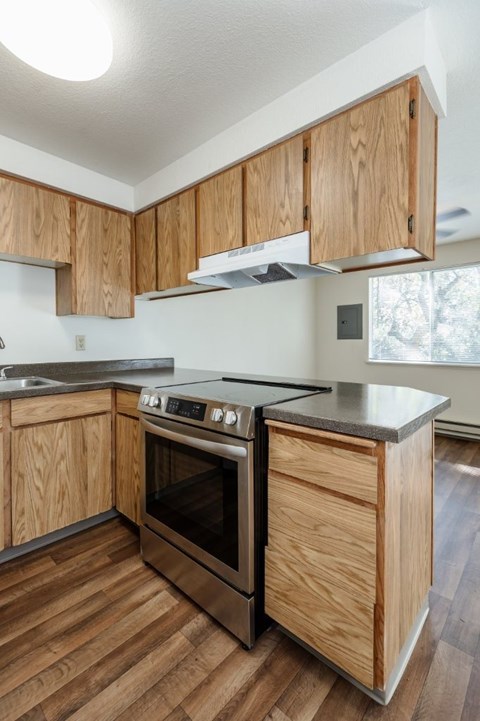 A kitchen with wooden cabinets and a black countertop.