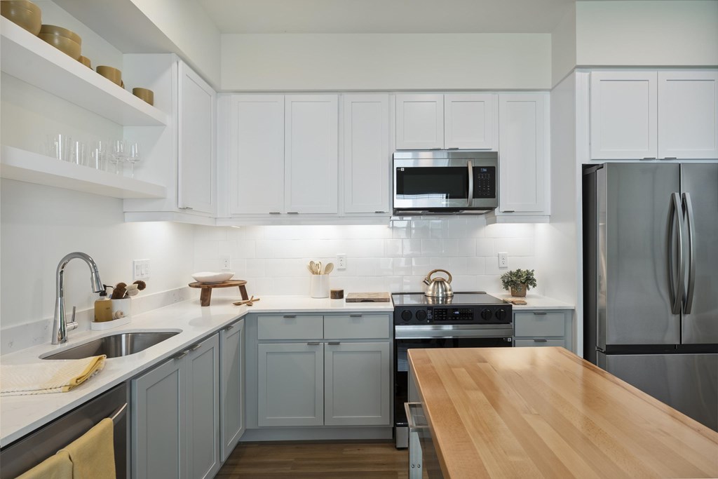 A kitchen with a wooden table and a refrigerator.