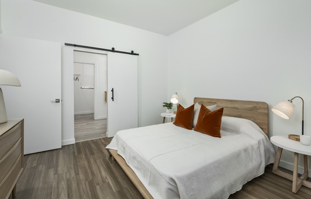 A bedroom with a bed, nightstand, and lamp.