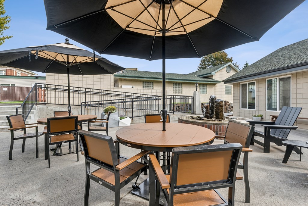 A patio with a table and chairs under an umbrella.