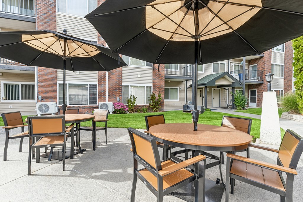 A patio with a table and chairs under an umbrella.