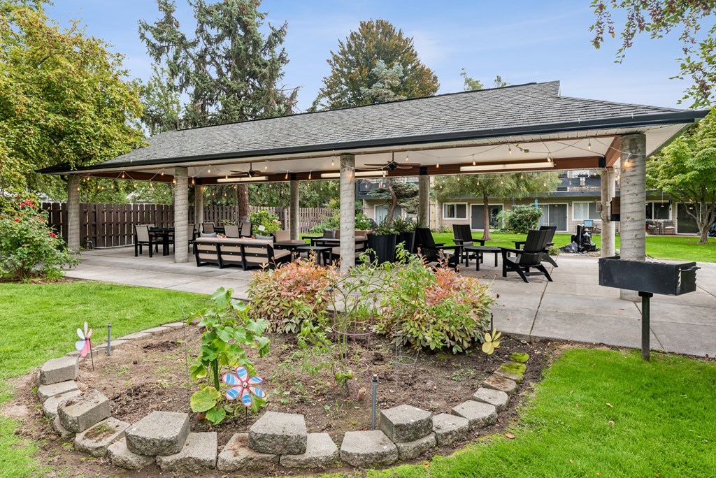 A gazebo is surrounded by a circular garden with a mailbox on the right.