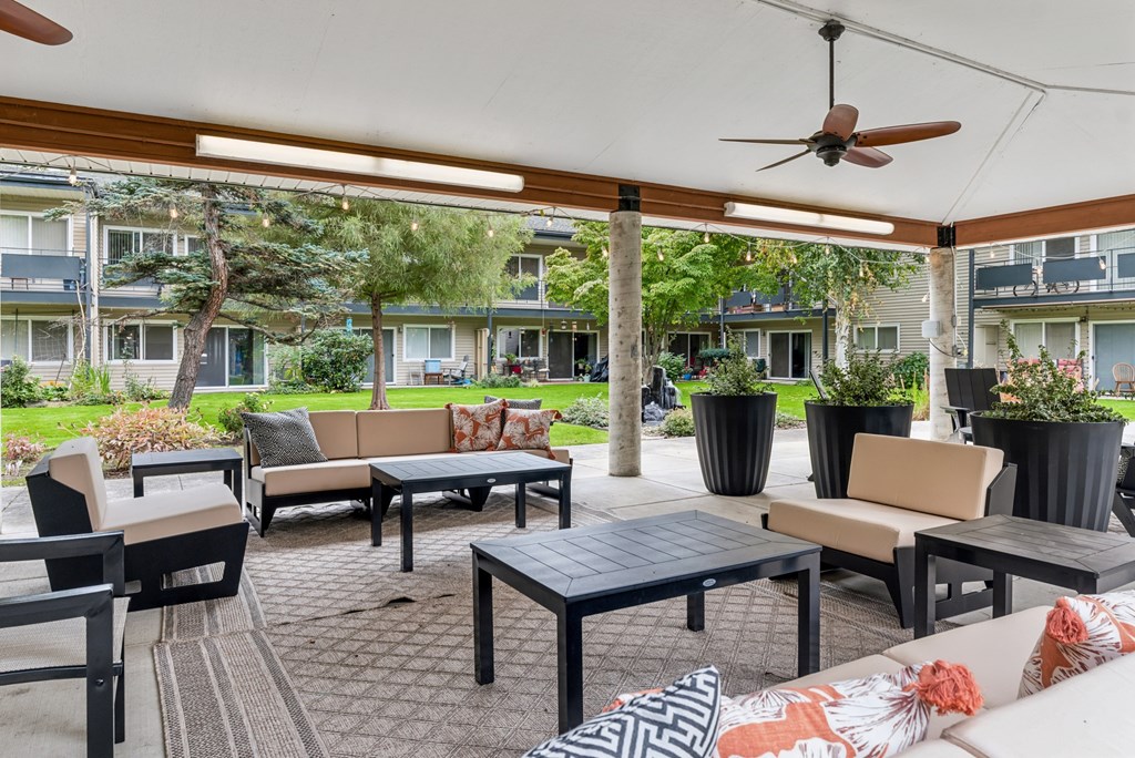 A patio with a table and chairs under a white canopy.