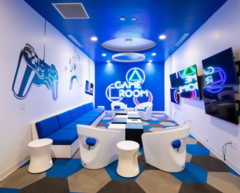 A game room with a blue and white color scheme and a variety of gaming equipment.