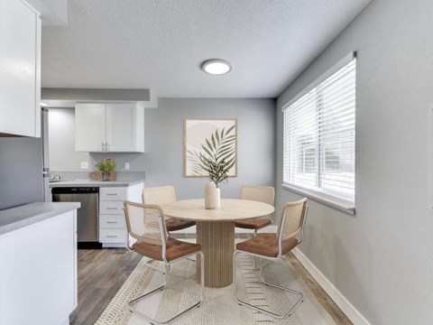 A dining room with a round table and chairs.