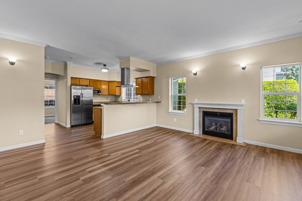 Little Tuscany Apartments & Townhomes - Living Room with Fireplace, Breakfast Bar, Kitchen with Stainless Steel Appliances, Wood Plan Vinyl Flooring, White Woodwork