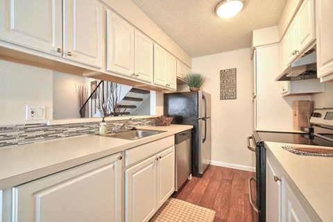 a kitchen with white cabinets and a black refrigerator