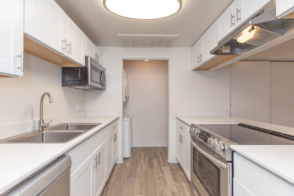 A kitchen with white cabinets and stainless steel appliances.