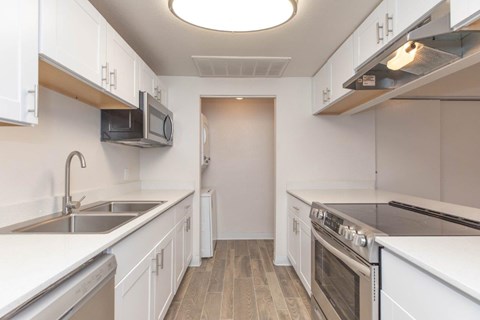 A kitchen with white cabinets and stainless steel appliances.