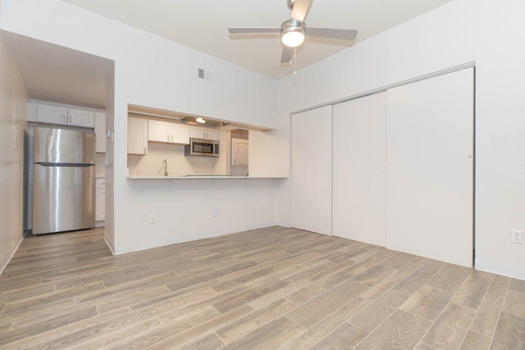 A kitchen area with a refrigerator, microwave, and cabinets.