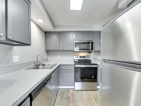 a kitchen with stainless steel appliances and white counter tops