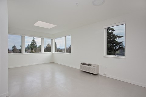 a living room with a large window and a radiator on the floor