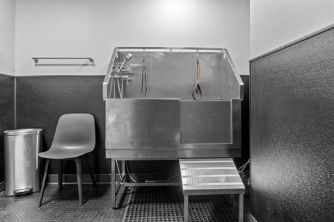 A clean, empty kitchen with a sink and a chair.
