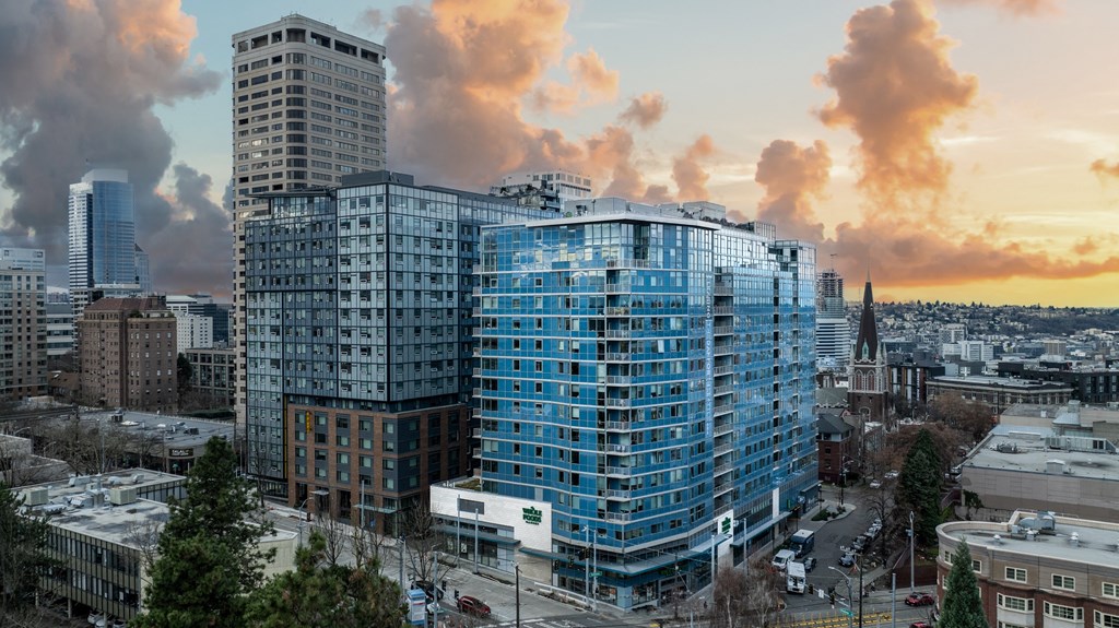 a sunset over a cityscape with tall buildings