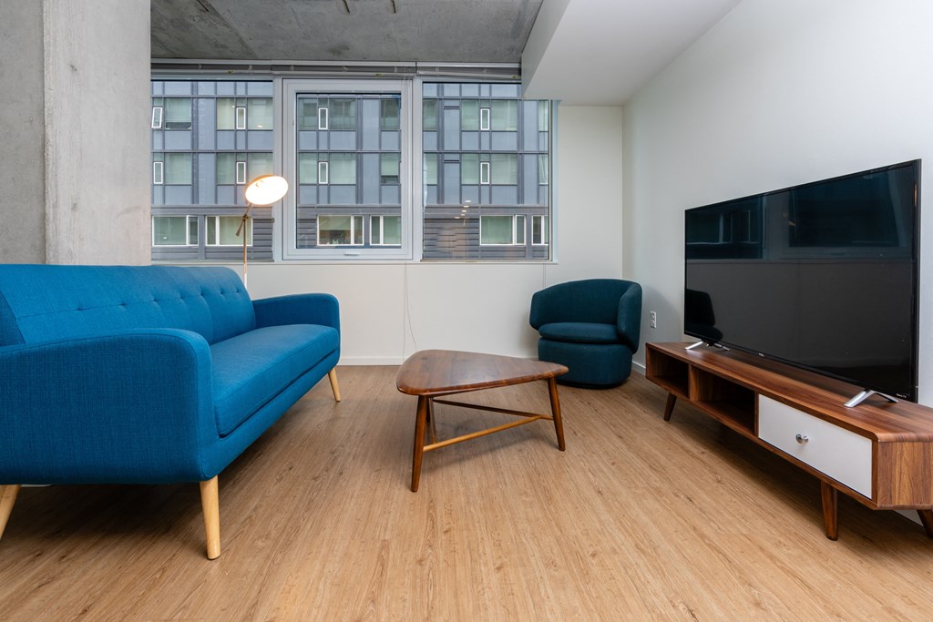 a living room with a blue couch and a television