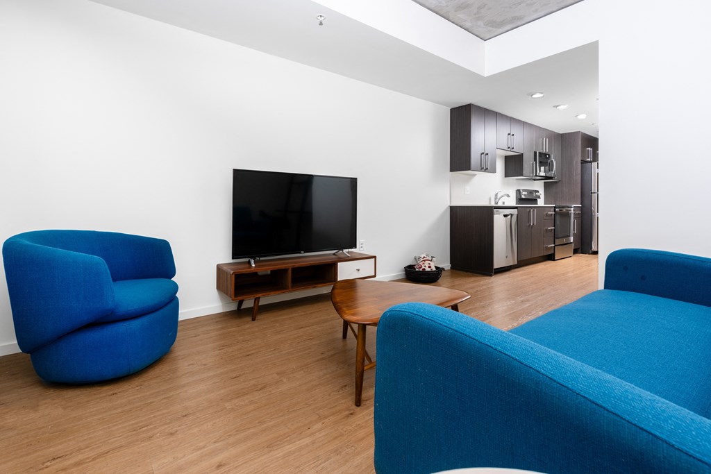 a living room with two blue chairs and a television