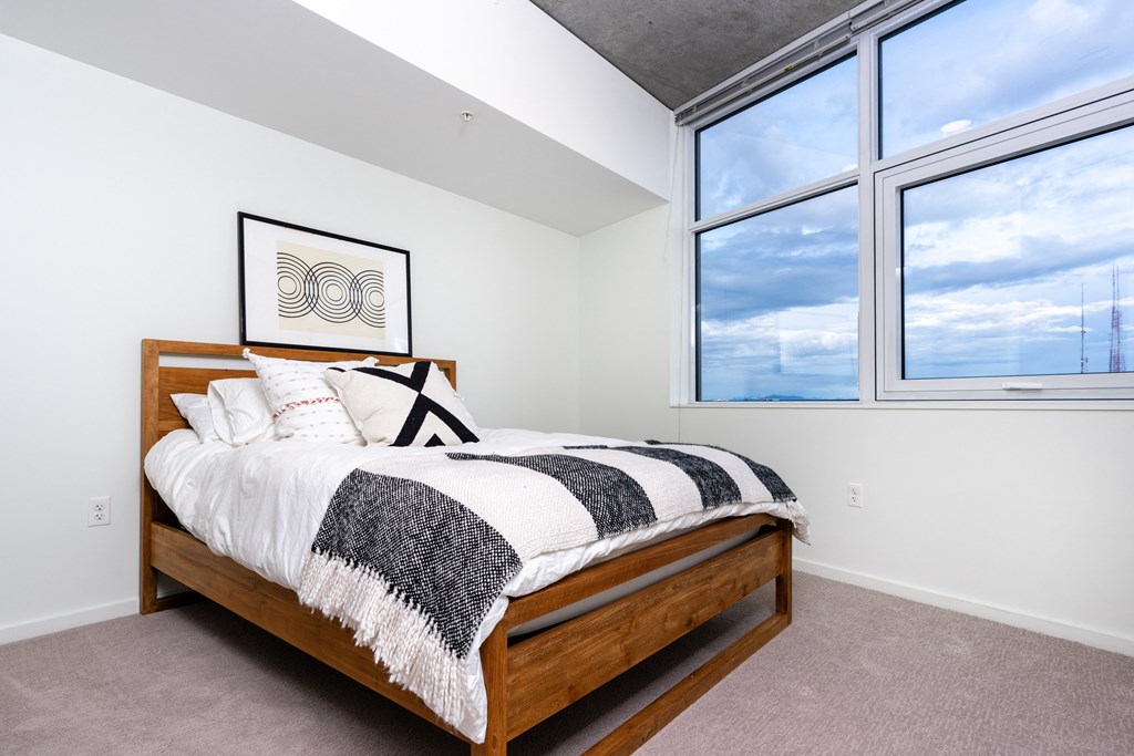 a bedroom with a bed and two windows