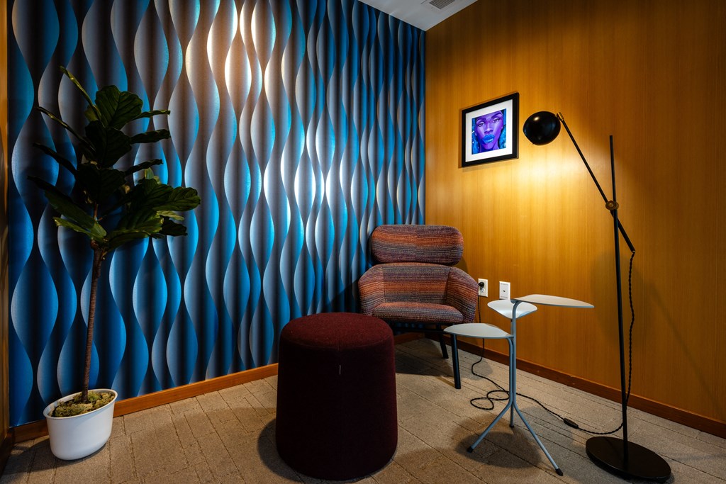 a room with a chair and a lamp and a plant